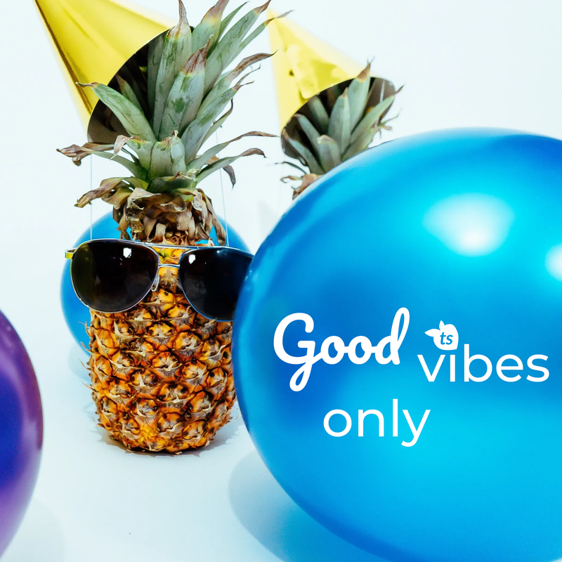 Pineapple with sunglasses and party hats surrounded by balloons. Good Vibes Only.