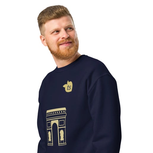 Stylish man wearing navy sweatshirt with gold Arc de Triomphe design.